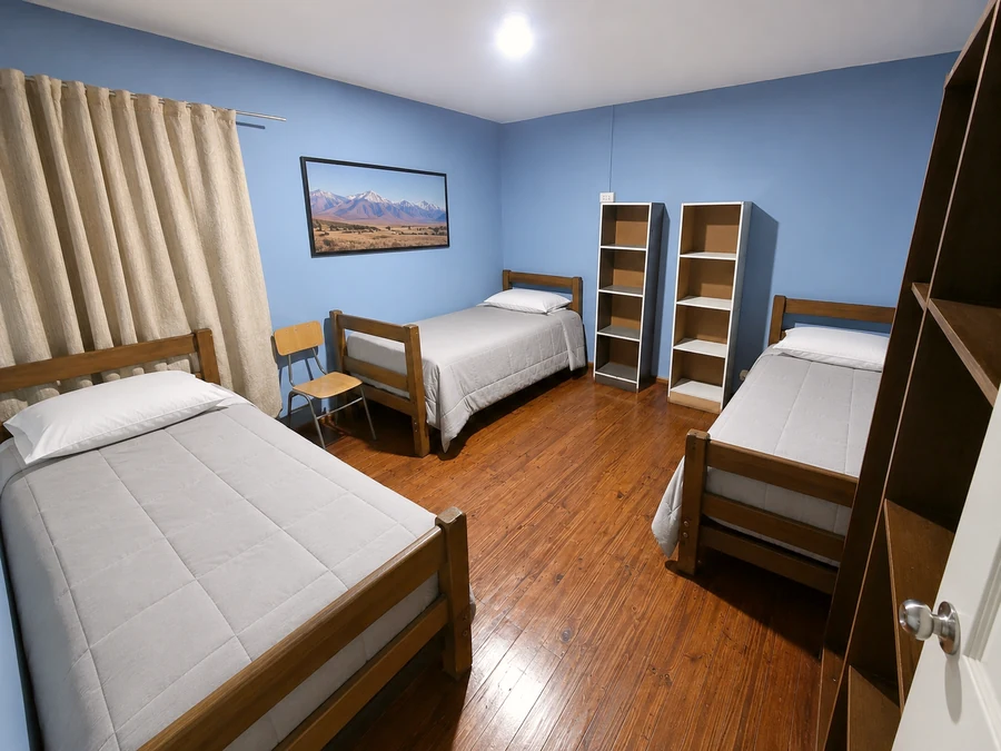 Dormitorio para trabajadores de empresas mineras, con tres camas, estantes y ropa de cama uniforme